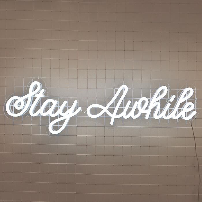 Stay Awhile Neon Sign perfect for cozy living room settings